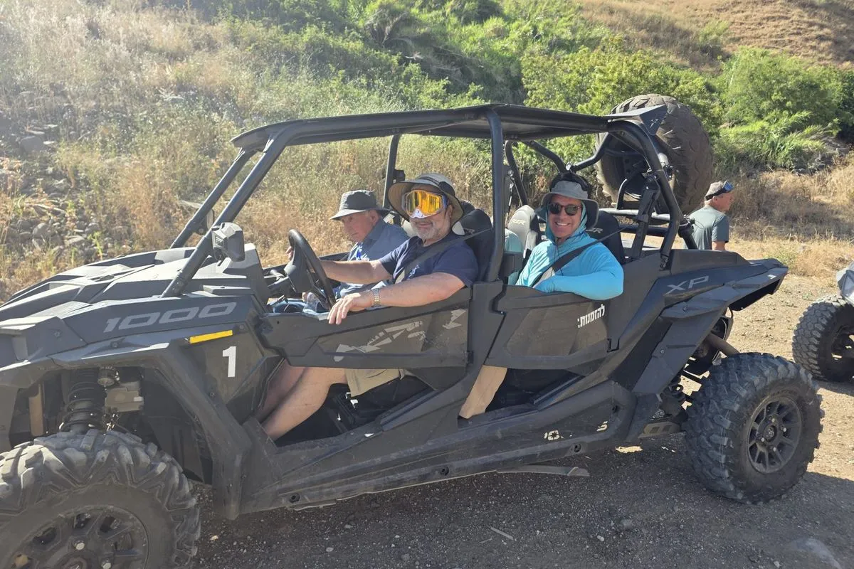 Mission participants driving ATVs on a dirt track in the hills