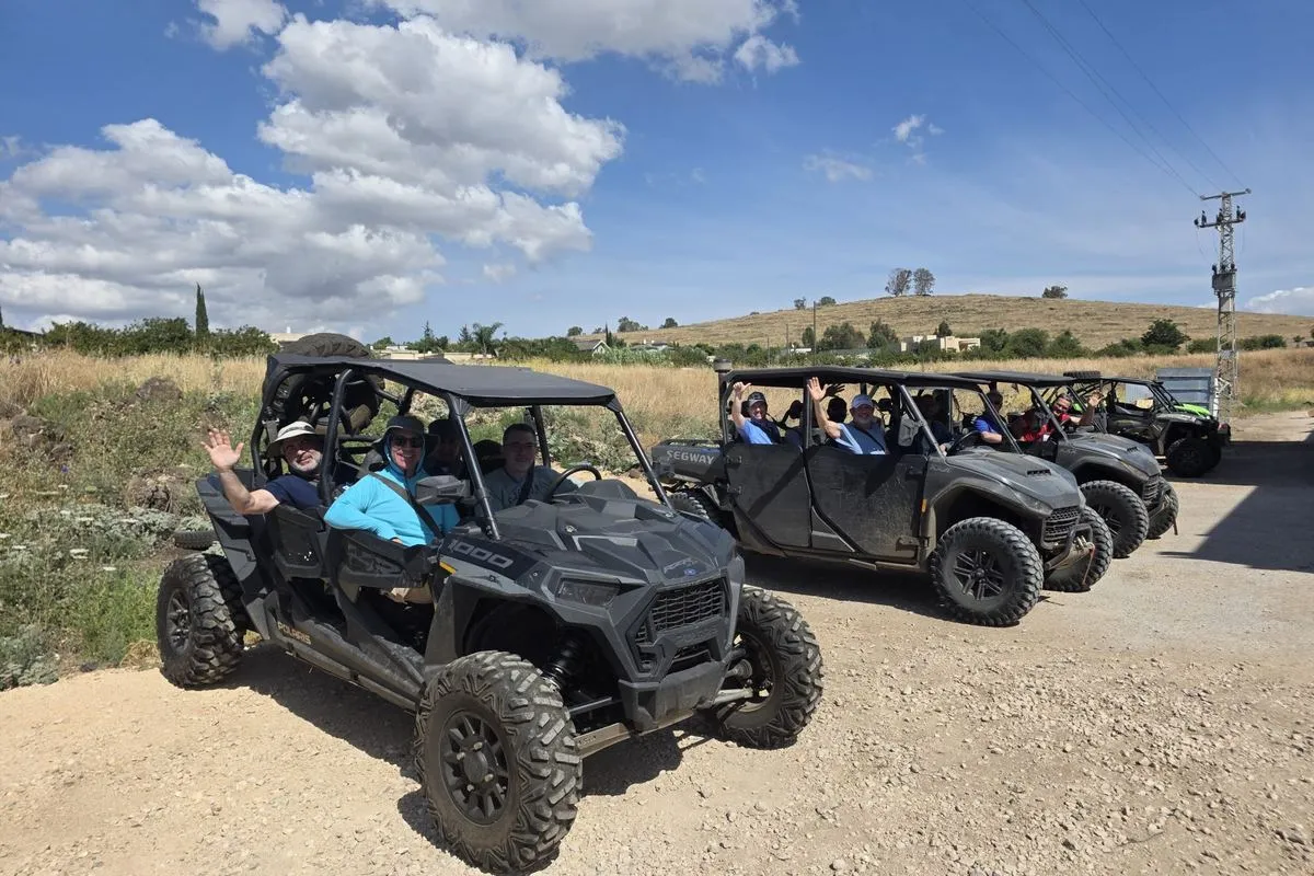 Mission participants in a line of off-road buggies on a dirt track