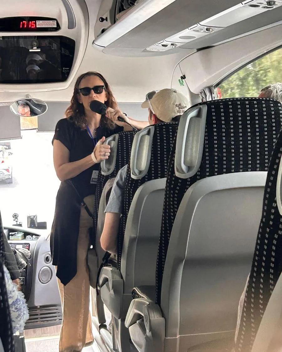 A guide speaks to participants on the mission bus
