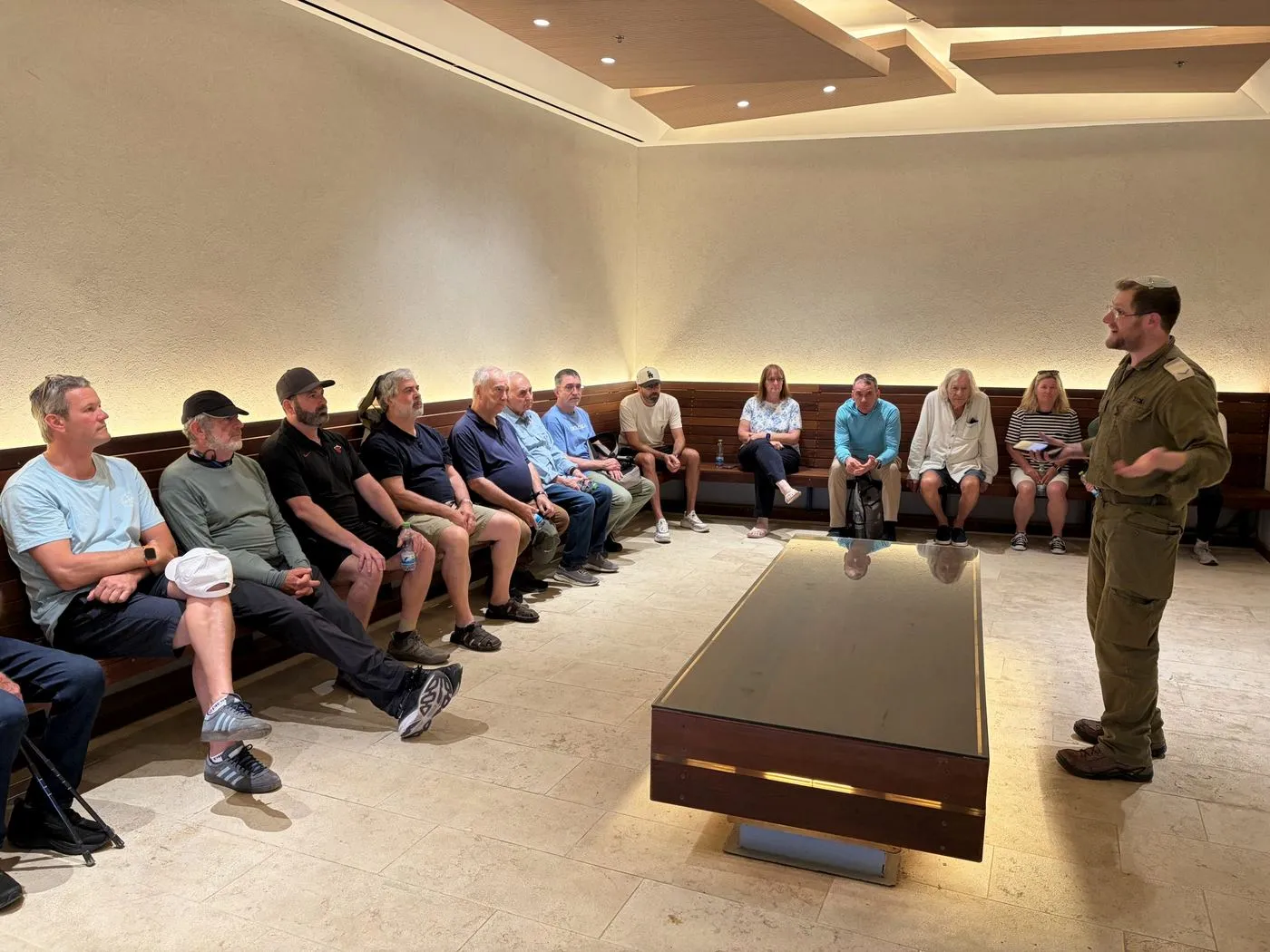 An officer in uniform briefs seated mission participants