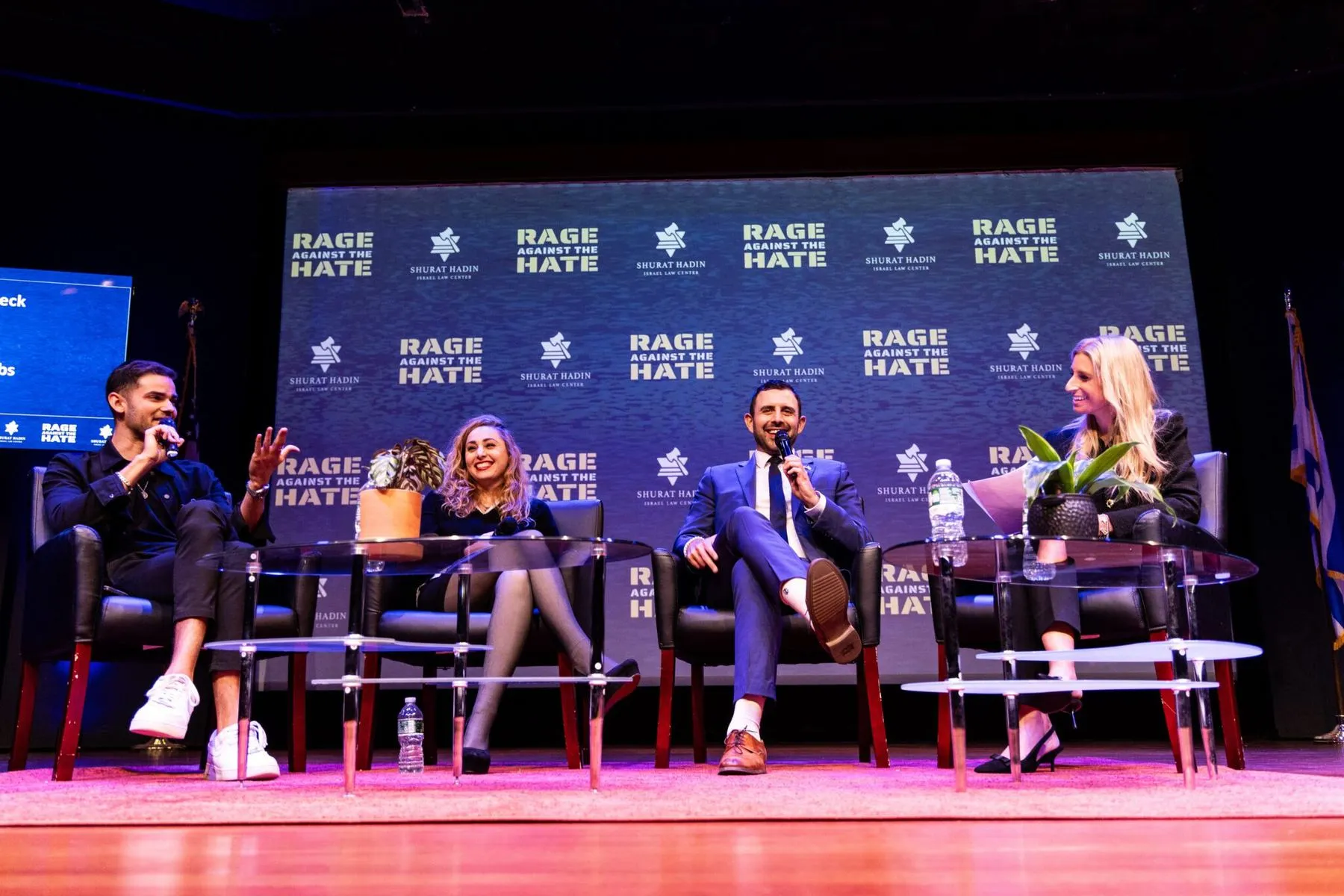 Four panelists in conversation on the Rage Against the Hate stage in 2025, under the conference’s banner