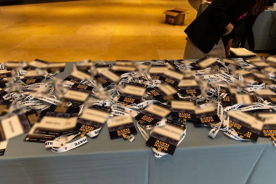 Rage Against the Hate name badges and lanyards laid out on the registration table